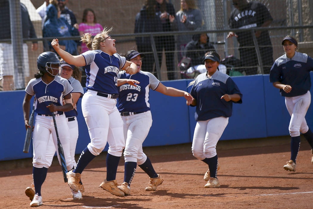 Shadow Ridge players celebrate a home run by Caitlin Covington, not pictured, during the second ...