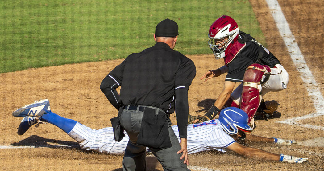 Reno's Skylar Hales (24) just beats the tag at home plate by Desert Oasis catcher Parker Schmid ...