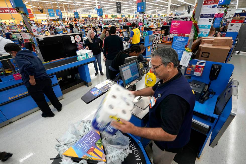 FILE - In this Nov. 9, 2018, file photo Walmart associate Javaid Vohar, right, checks out custo ...