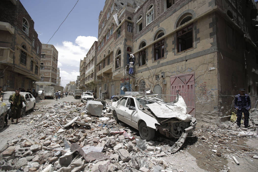 People inspect the site of an airstrike by Saudi-led coalition in Sanaa, Yemen, Thursday, May, ...