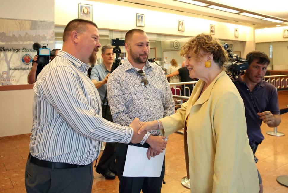 County Clerk Lynn Goya, right, congratulates James Johnson, left, and his partner, Matthew Tipp ...