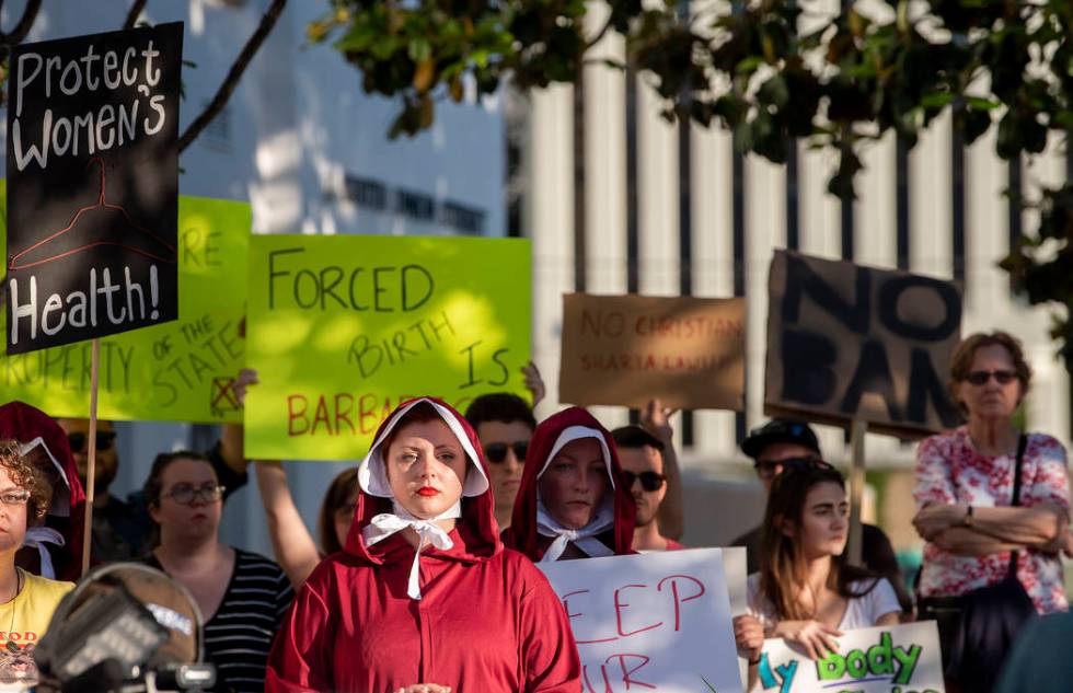 Margeaux Hartline, dressed as a handmaid, protests against a ban on nearly all abortions outsid ...