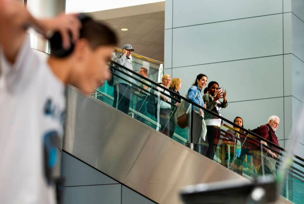 Travelers arrive as DJ Play performs for them including EDC visitors coming through Terminal 3 ...