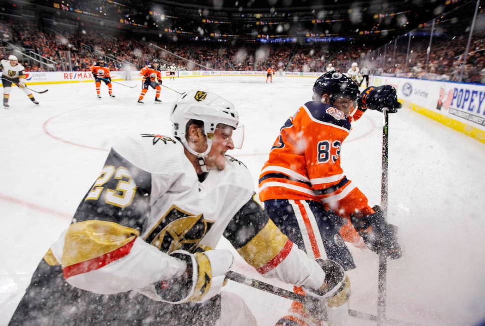 Vegas Golden Knights' Daniel Carr (23) and Edmonton Oilers' Matthew Benning (83) battle for the ...