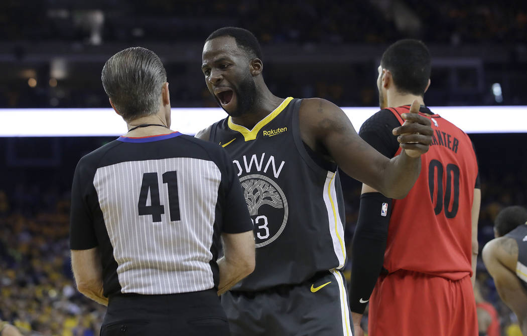 Golden State Warriors forward Draymond Green gestures while talking with referee Ken Mauer (41) ...