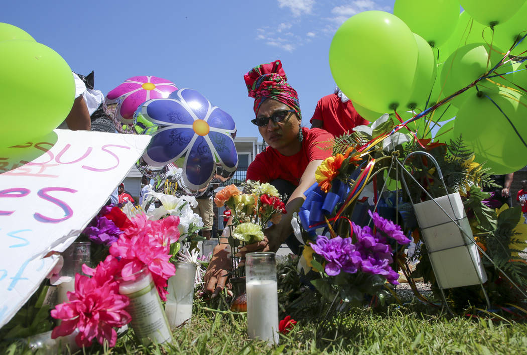 Ahsaki Chachere arranges flowers Wednesday, May 15, 2019, at the memorial for Pamela Turner, wh ...