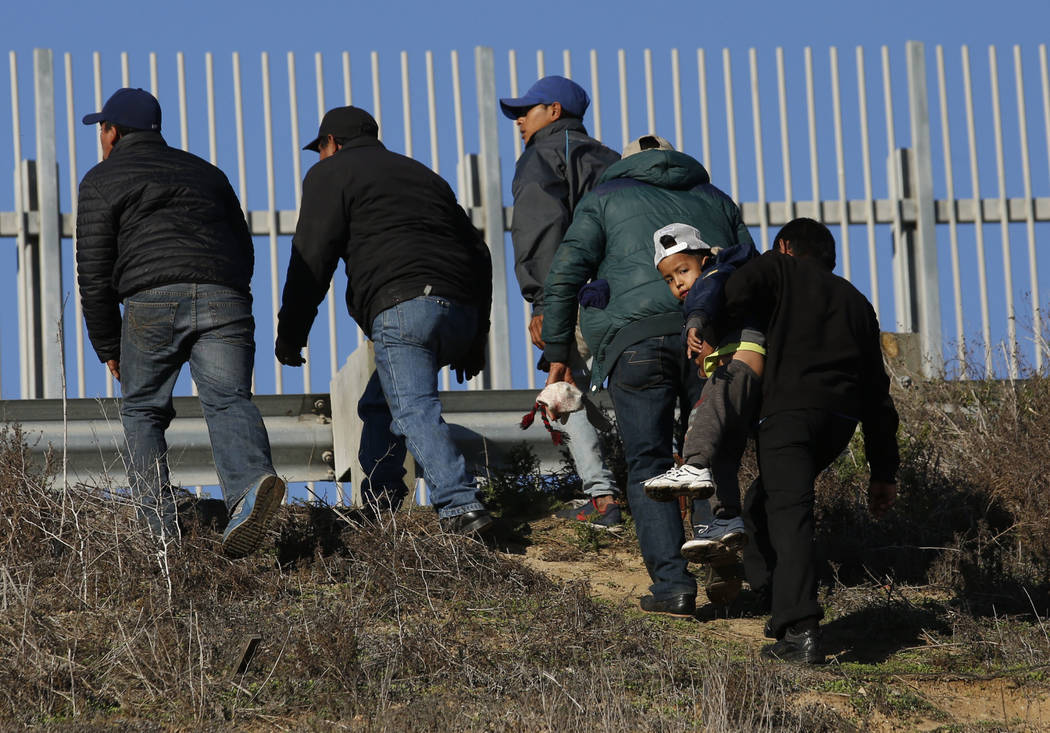 FILE - In this Dec. 12, 2018 file photo, Honduran migrants, one carrying a child, who plan to t ...