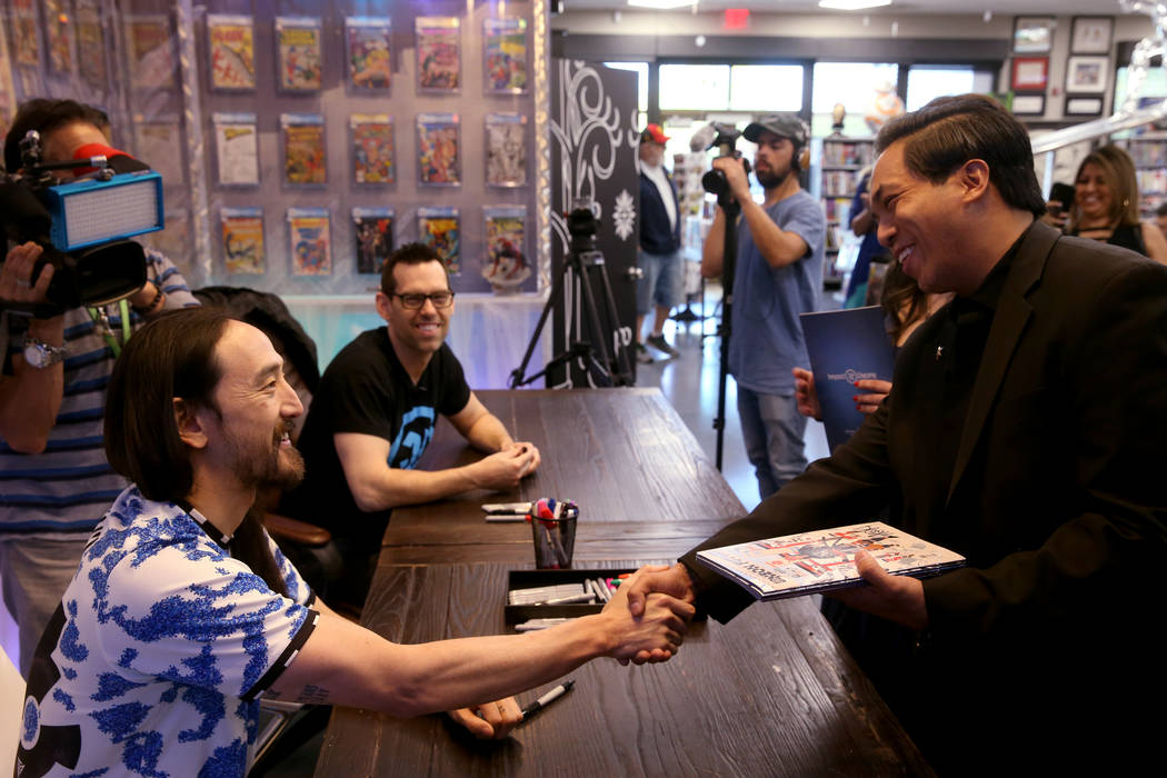 DJ Steve Aoki, left, greets Jasper Gonzales of Las Vegas during a signing for his new comic boo ...
