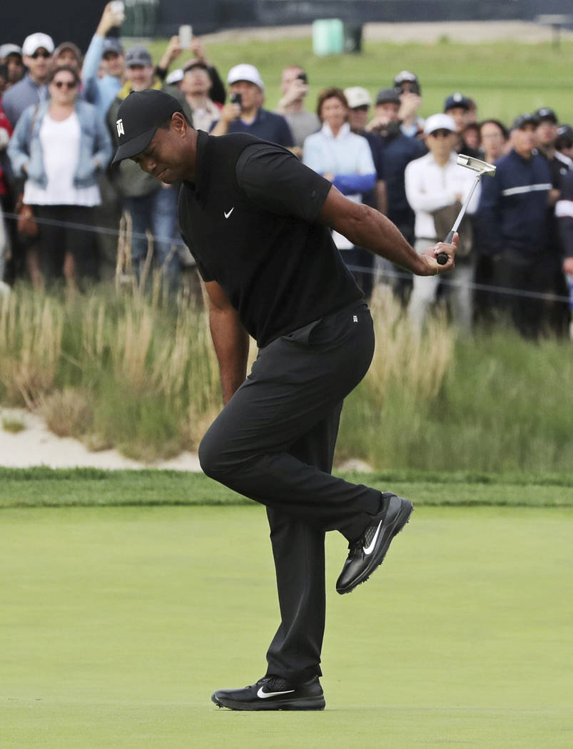 Tiger Woods reacts after missing a putt for birdie on the 17th green during the second round of ...
