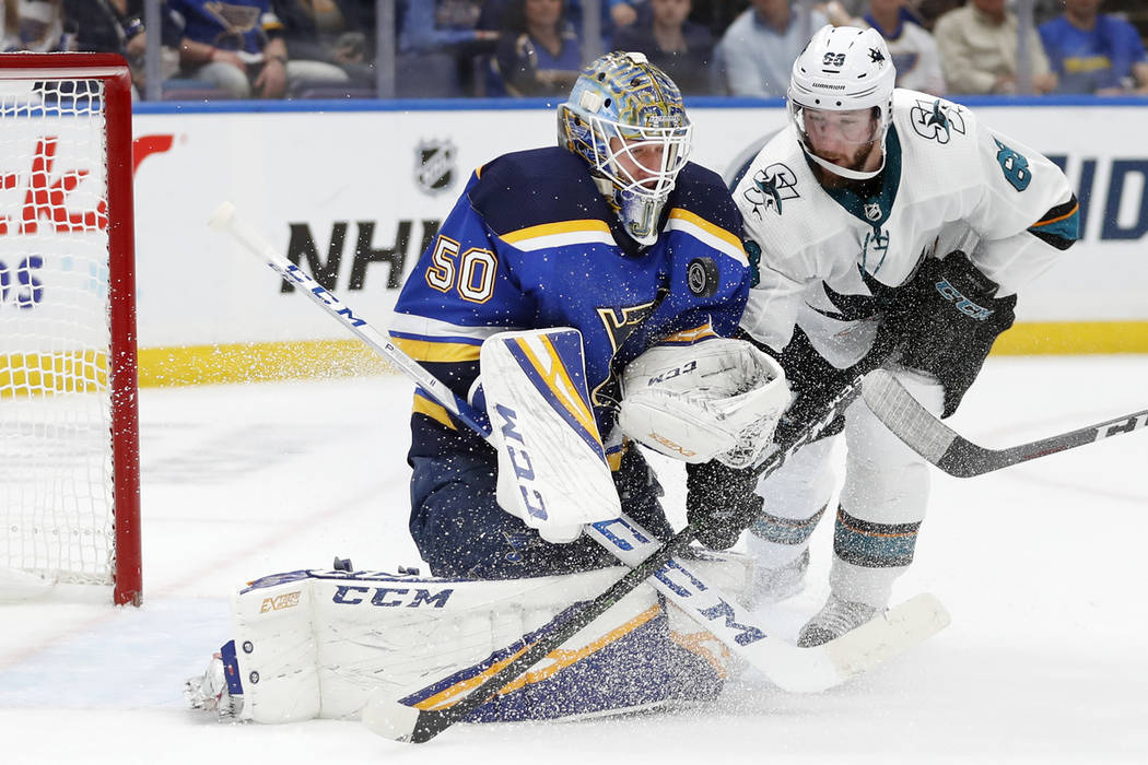 St. Louis Blues goaltender Jordan Binnington (50) protects the puck as San Jose Sharks center M ...