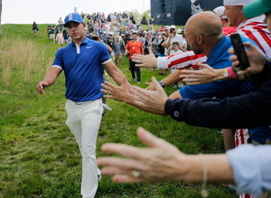 Brooks Koepka greets spectators as he walks down to the 15th tee during the second round of the ...