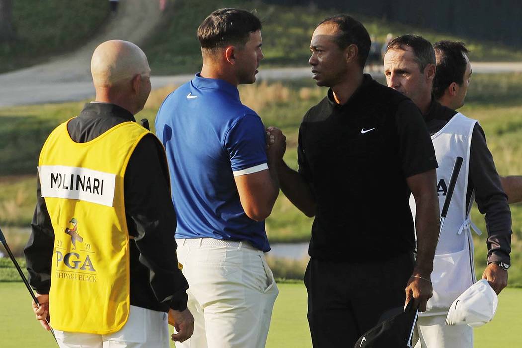 Brooks Koepka and Tiger Woods shake hands after finishing the second round of the PGA Champions ...