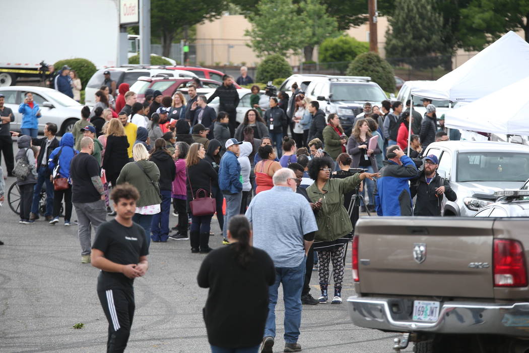 Students gather outside Parkrose High School during a lockdown after a man armed with a gun wa ...