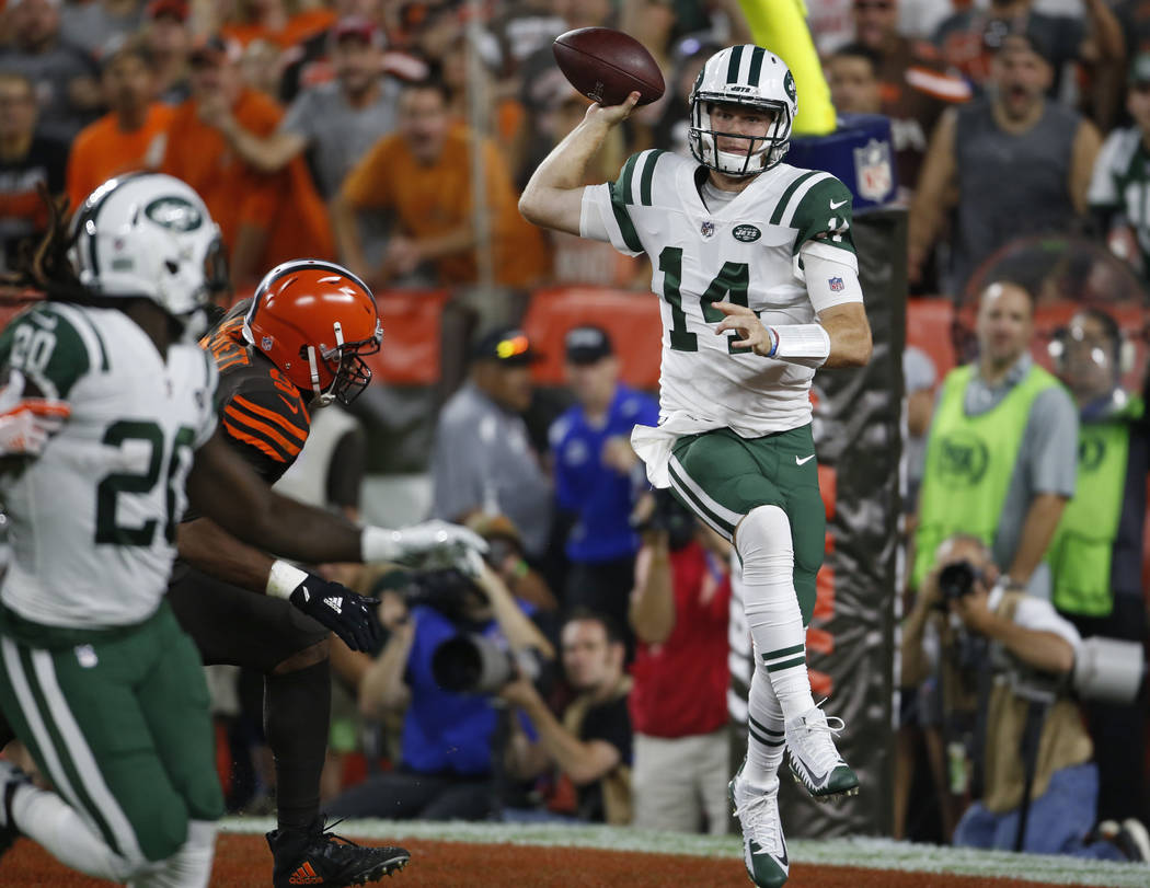 New York Jets quarterback Sam Darnold, right, throws a pass against the Cleveland Browns during ...