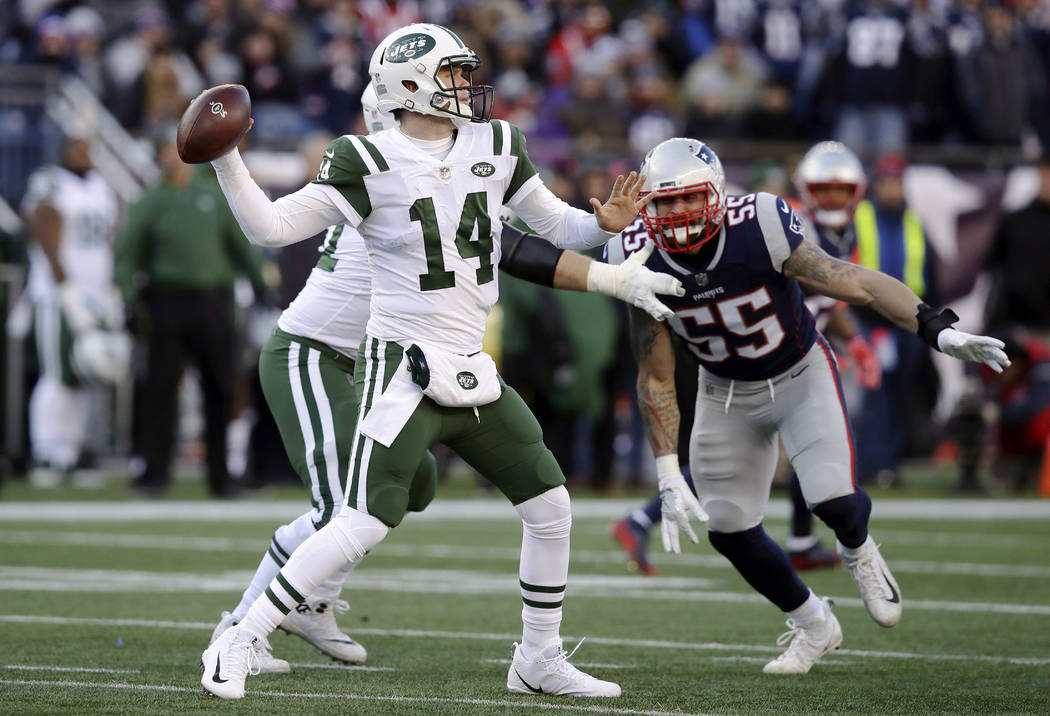 New York Jets quarterback Sam Darnold, left, passes under pressure from New England Patriots de ...