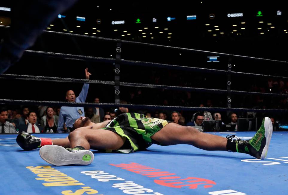 Dominic Breazeale lies on the mat after being knocked down by Deontay Wilder during the WBC hea ...