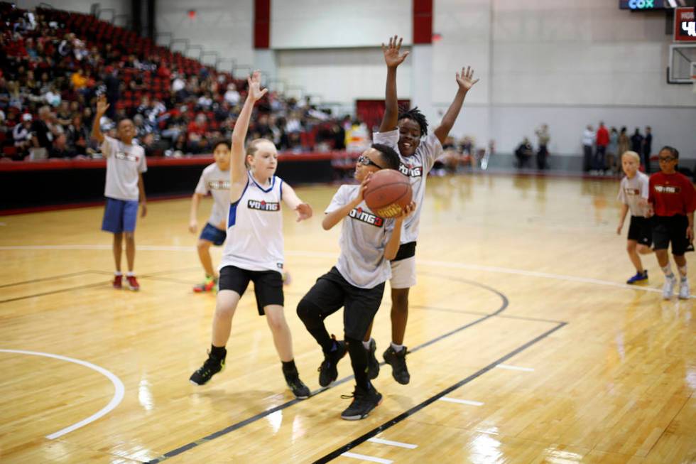 Kaelie Pernyall, 12, left, attempts to block Jackson Livingston, 10, alongside Micah Uthman, 10 ...