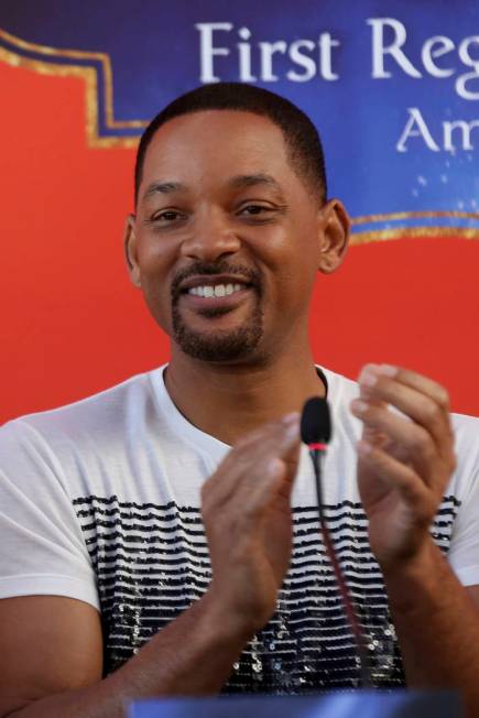 U.S. actor Will Smith applauds during a news conference with the director Guy Ritchie and stars ...