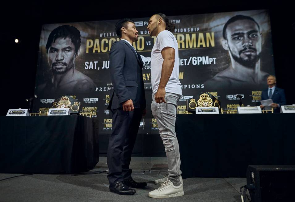 Manny Pacquiao, left, and Keith Thurman stand face to face during a news conference, Tuesday, M ...