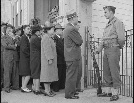 People wait to register as an armed guard watches in this undated photo. Sam Mihara showed it d ...