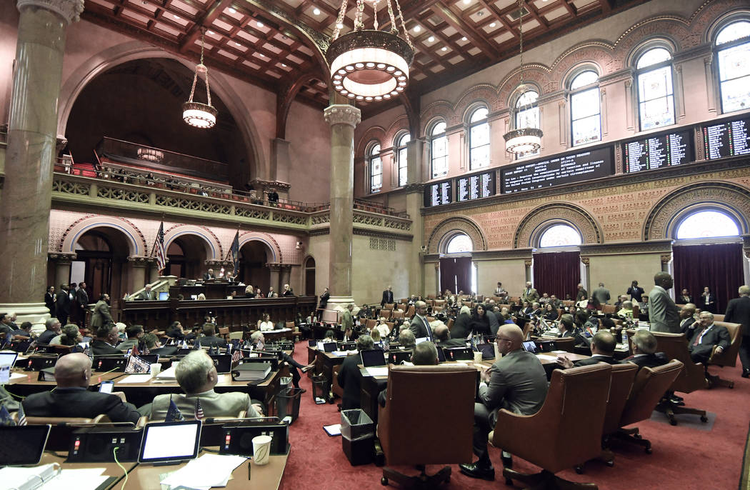 Members of the New York state Assembly vote on legislation that authorizes state tax officials ...