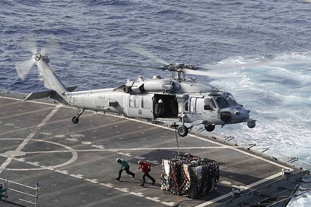 In this Sunday, May 19, 2019 photo, an MH-60S Sea Hawk helicopter transports cargo from the fas ...