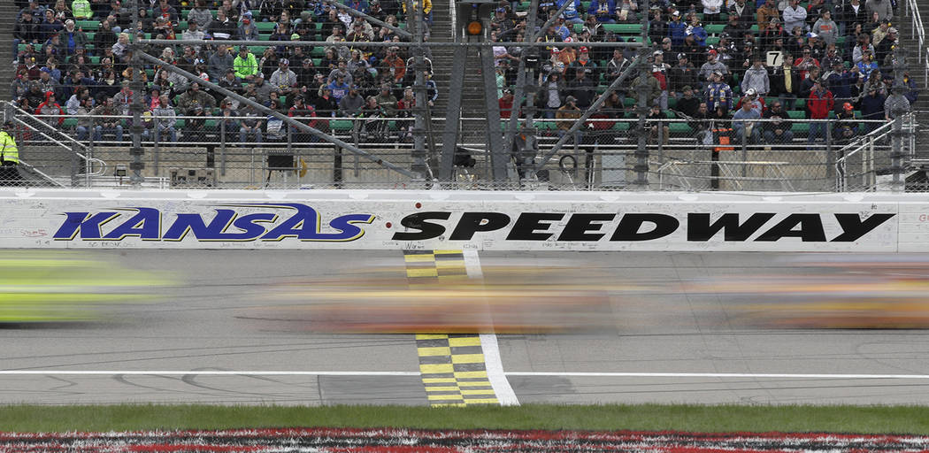 Drivers cross the start/finish line early in theNASCAR Cup Series auto race at Kansas Speedway ...