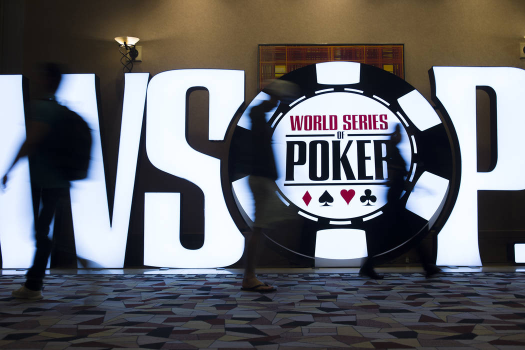 People walk past a World Series of Poker sign day five of the competition at the Rio Convention ...