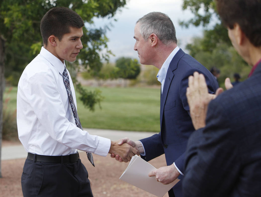 Gabriel Pence, 17, shakes hands with Tom Kovach, the executive director of the LVMPD Foundation ...
