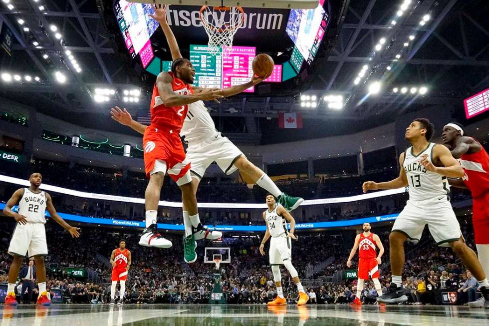 Toronto Raptors' Kawhi Leonard shoots past Milwaukee Bucks' Brook Lopez during the second half ...