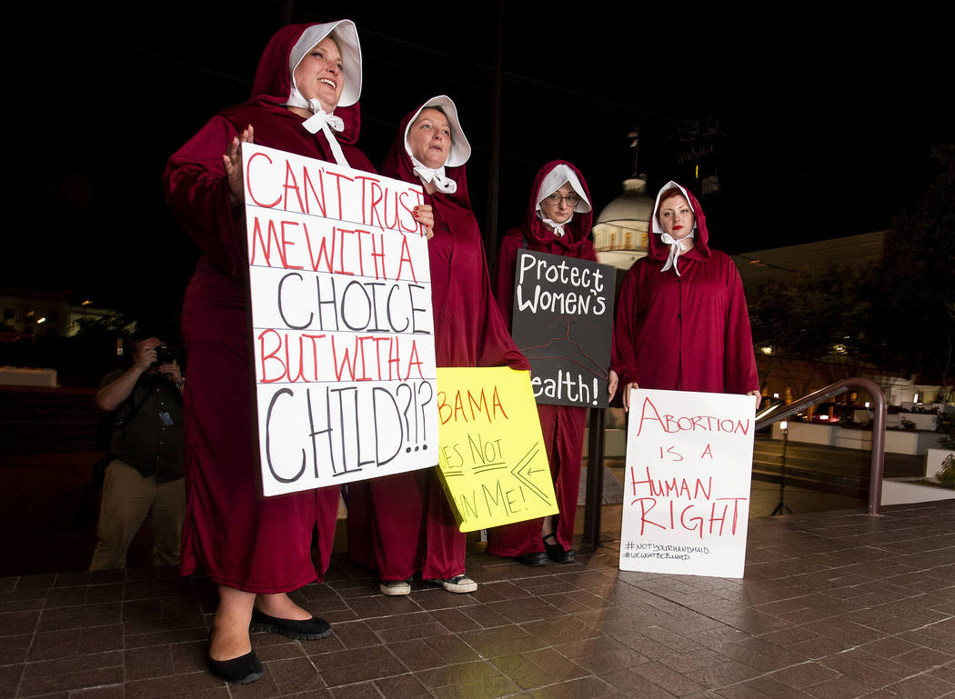 FILE - In this Tuesday, May 14, 2019, file photo, protesters, dressed as handmaids, from left, ...