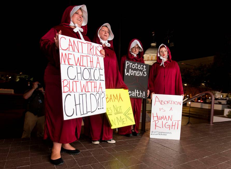 FILE - In this Tuesday, May 14, 2019, file photo, protesters, dressed as handmaids, from left, ...