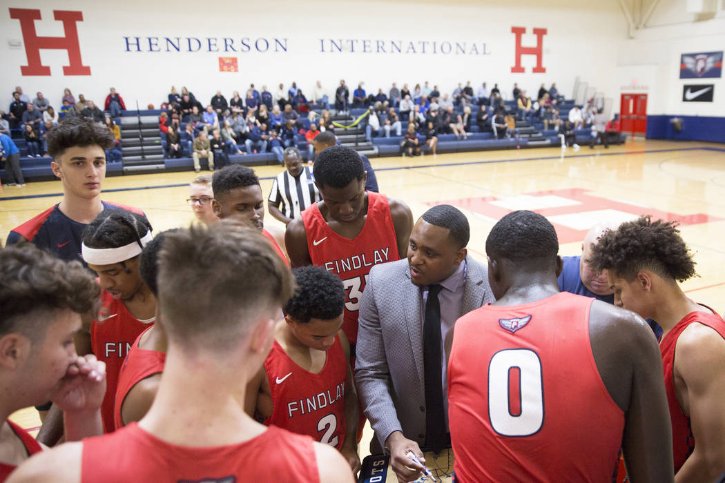 Findlay Prep head coach Rodney Haddix, right, draws up a play during a timeout during the Pilot ...