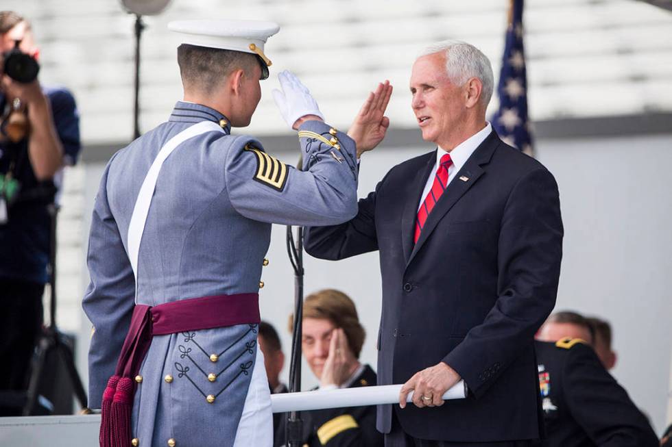 Vice President Mike Pence salutes a graduating cadet before handing him his diploma during grad ...