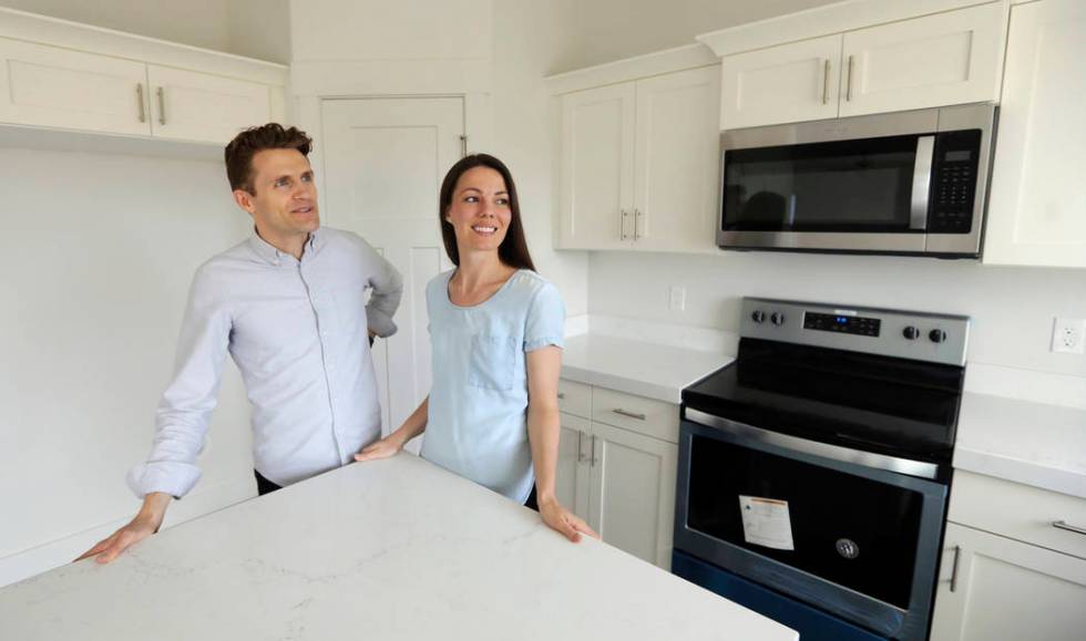 Andy and Stacie Proctor stand in their new home in Vineyard, Utah, in April 2019. (AP Photo/Ri ...