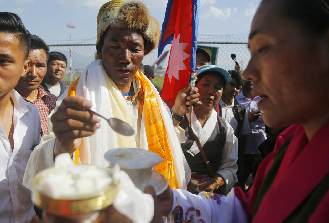 Nepalese veteran Sherpa guide Kami Rita, 49, is welcomed by his wife at the airport in Kathmand ...