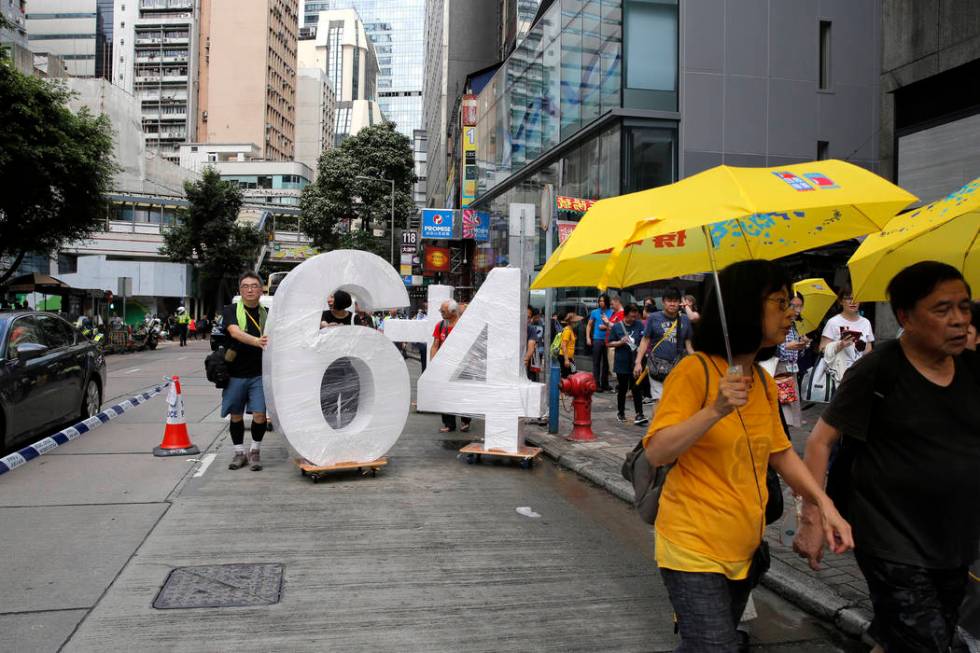 Pro-democracy protesters carry a sculpture featuring "June 4th" during a demonstratio ...