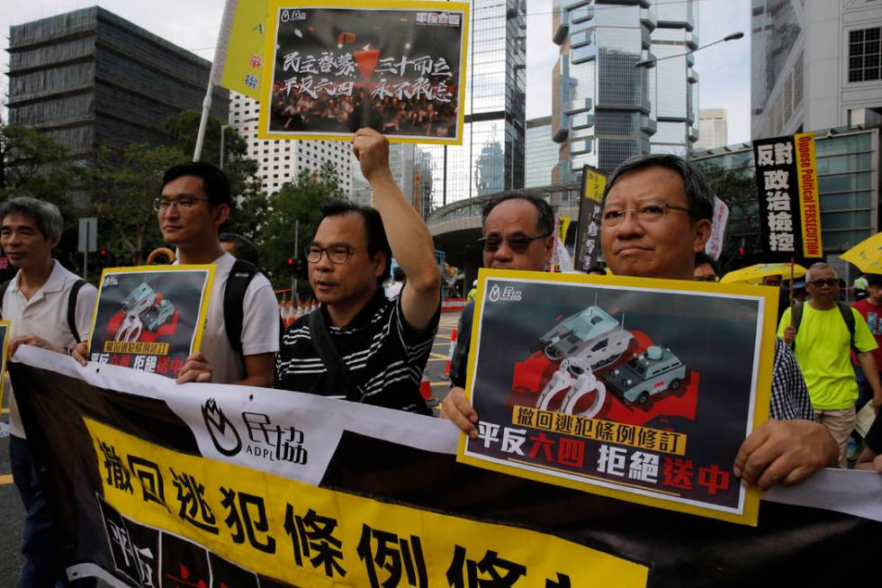 Pro-democracy demonstrators carry placards with Chinese reads "Withdraw extradition law, V ...