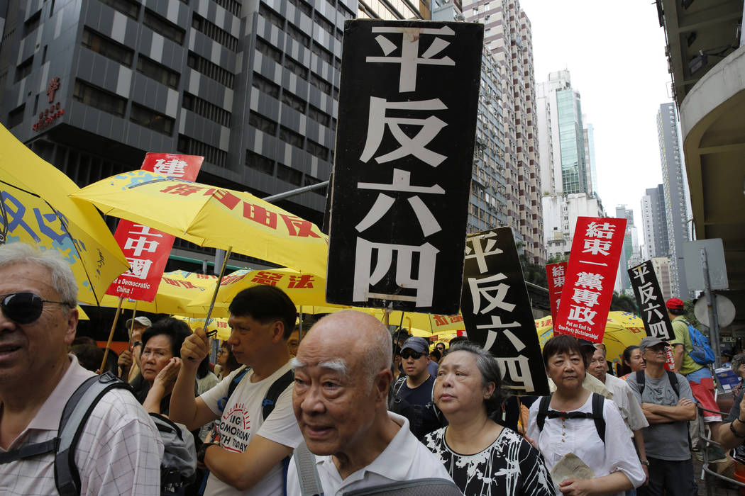 Pro-democracy protesters carry placards with Chinese reads "Vindicate June 4th" and & ...