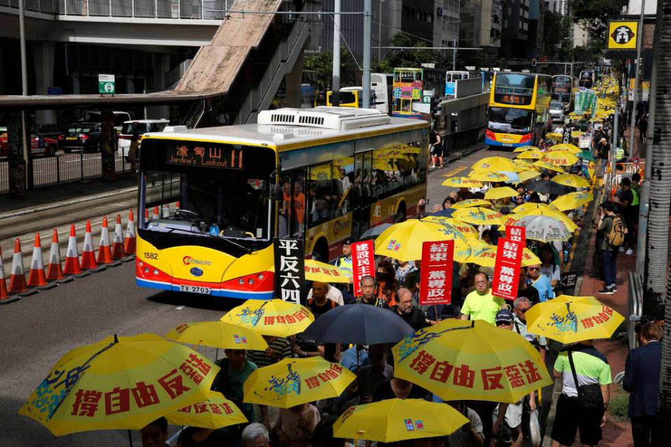 Pro-democracy protesters carry a banner with Chinese reads "Vindicate June 4th" durin ...