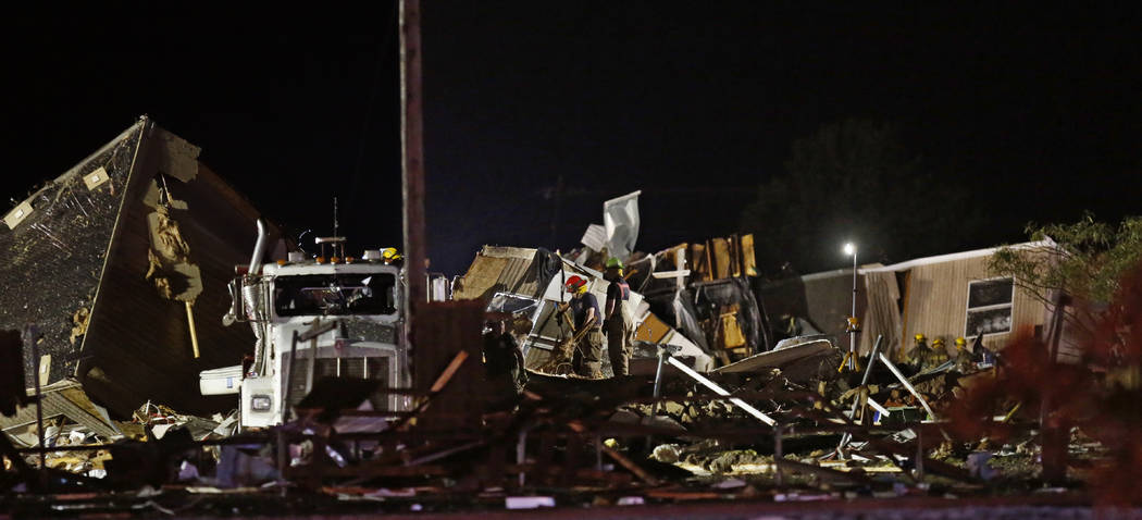 Emergency workers search through debris from a mobile home park, Sunday, May 26, 2019, in El Re ...