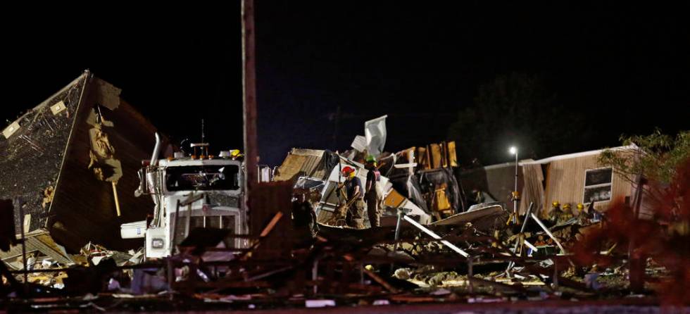 Emergency workers search through debris from a mobile home park, Sunday, May 26, 2019, in El Re ...