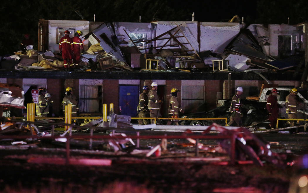 Emergency workers check what is left of the second floor of a hotel, Sunday, May 26, 2019, l in ...