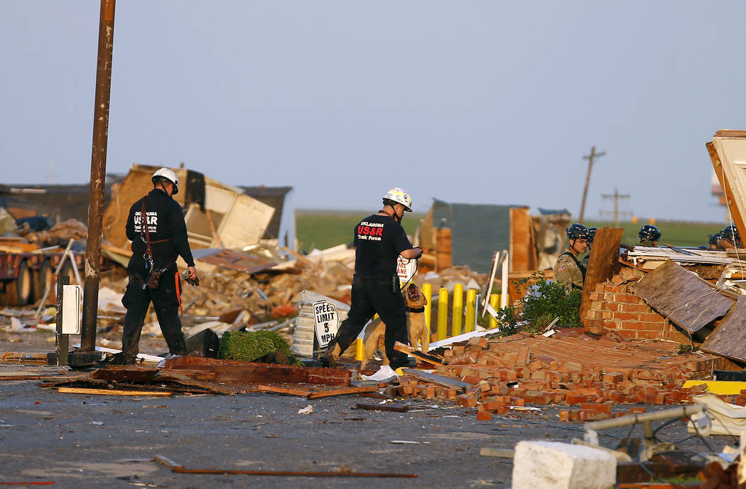 Workers look through tornado damage at the American Budget Value Inn in El Reno, Okla., Sunday, ...