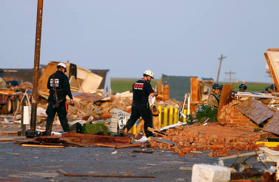 Workers look through tornado damage at the American Budget Value Inn in El Reno, Okla., Sunday, ...