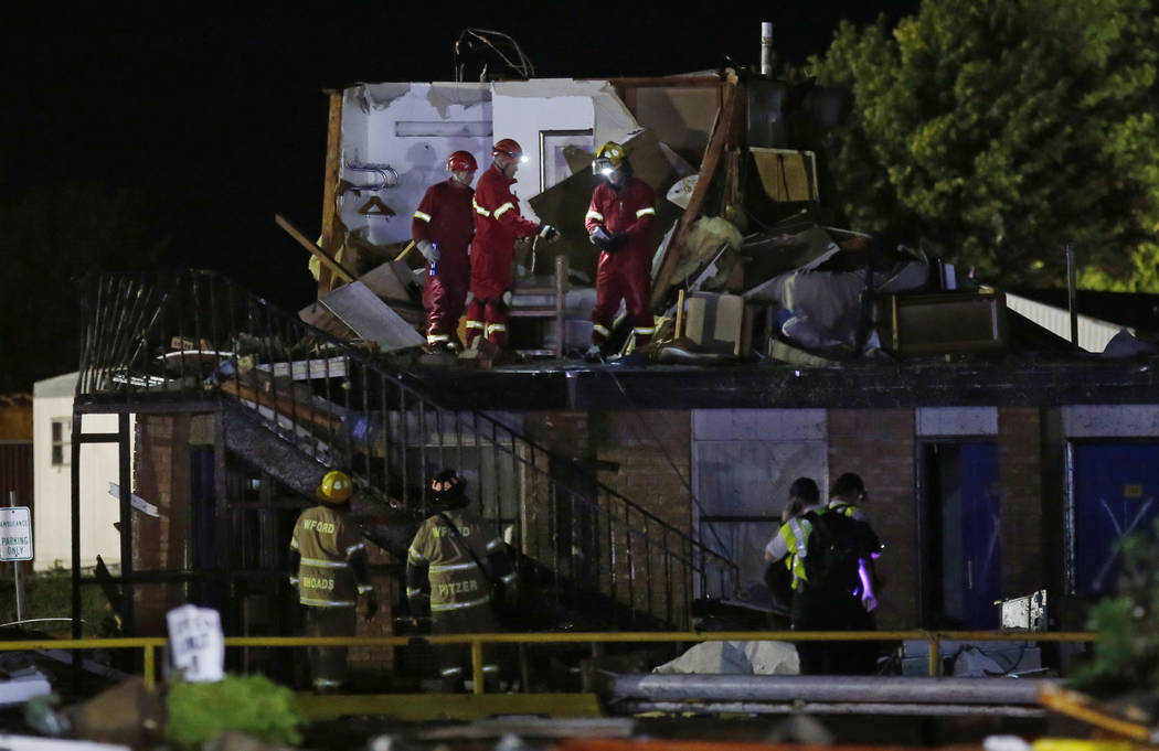 Emergency workers check what is left of the second floor of a hotel, Sunday, May 26, 2019, in E ...