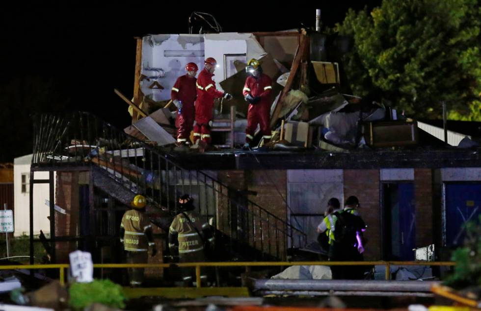 Emergency workers check what is left of the second floor of a hotel, Sunday, May 26, 2019, in E ...