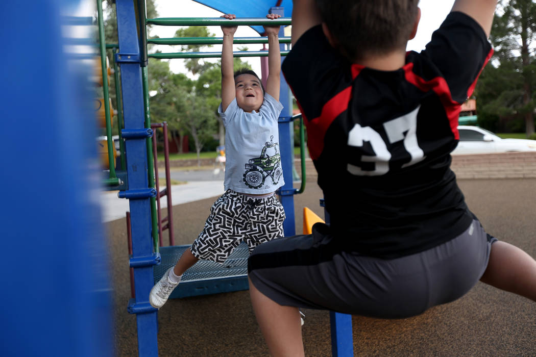 Alec Reyes, 5, climbs the monkey bars with his brother Eli Reyes, 10, right, at Bicentennial Pa ...