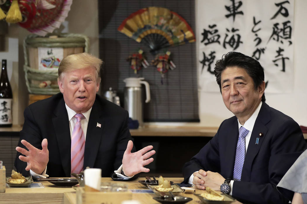 U.S. President Donald Trump, left, speaks as he dines with Japan's Prime Minister Shinzo Abe at ...