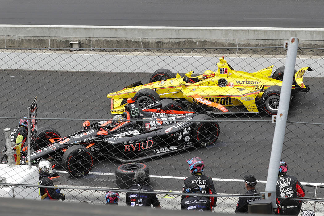 Helio Castroneves, of Brazil, rear, makes contact with James Davison, of Australia, during the ...